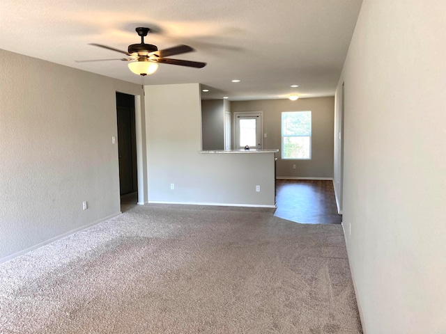 empty room with ceiling fan and carpet