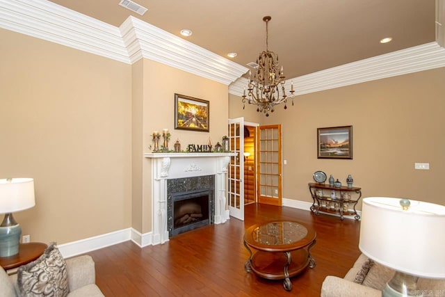 living room with ornamental molding, an inviting chandelier, a high end fireplace, and dark hardwood / wood-style flooring