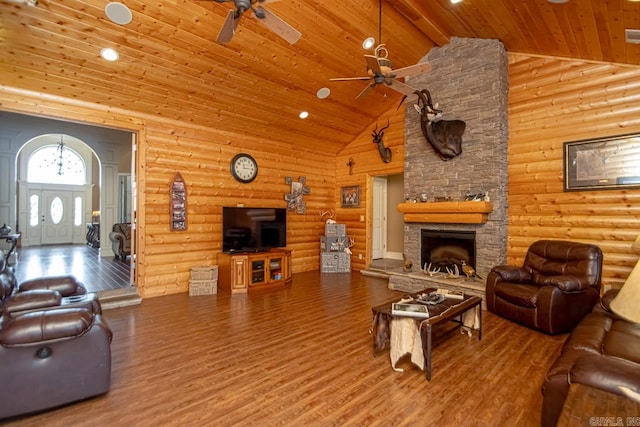 living room with rustic walls, high vaulted ceiling, hardwood / wood-style flooring, and ceiling fan