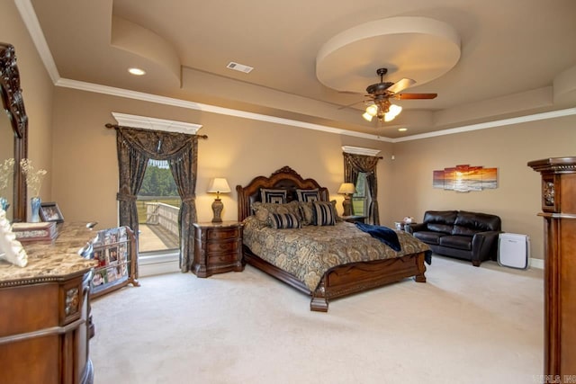 carpeted bedroom with a tray ceiling, ceiling fan, and crown molding