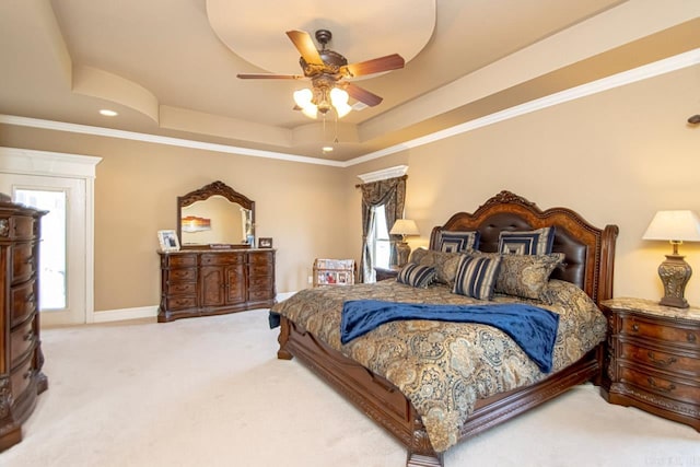 bedroom featuring ceiling fan, a raised ceiling, crown molding, and carpet floors