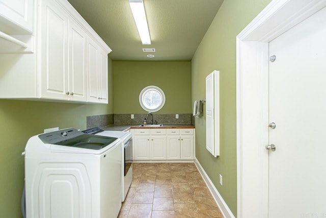 laundry room featuring separate washer and dryer, cabinets, and sink