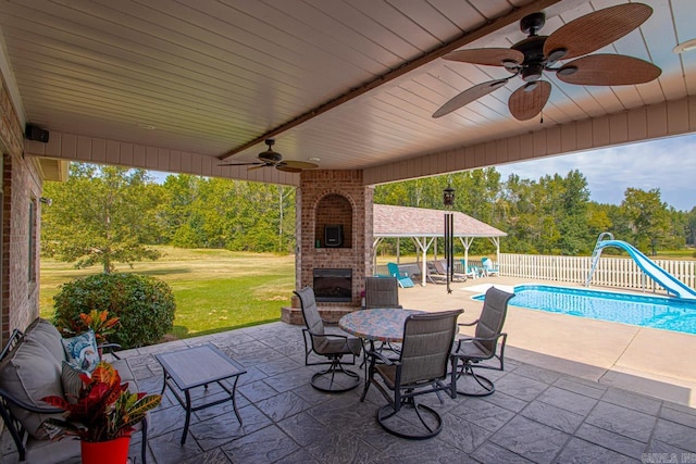 view of patio with ceiling fan and a fenced in pool