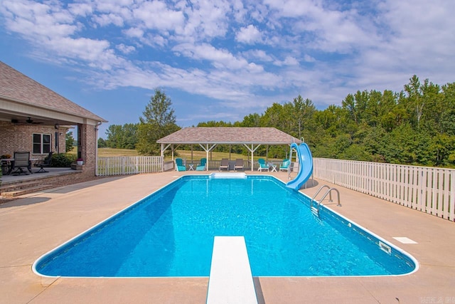 view of pool with a water slide, a diving board, a patio, and a gazebo