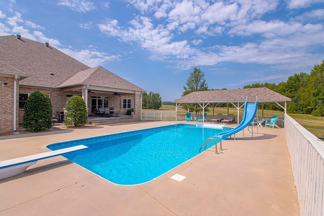 view of swimming pool featuring a water slide, a diving board, a gazebo, and a patio area