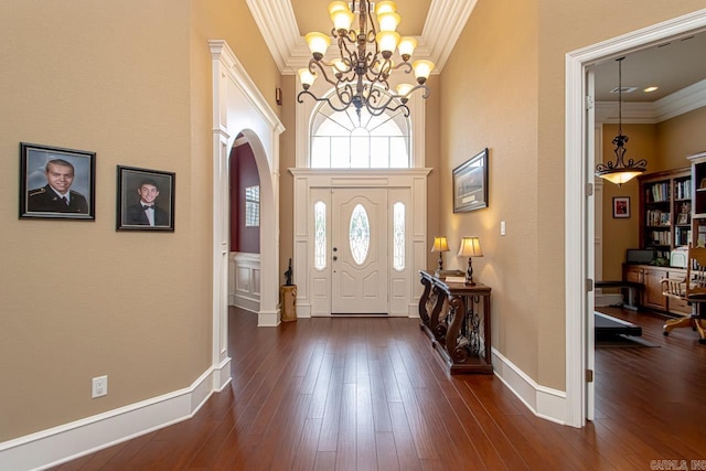 entryway with dark hardwood / wood-style flooring, a notable chandelier, and ornamental molding