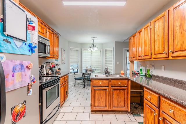 kitchen with light tile patterned floors, appliances with stainless steel finishes, brown cabinets, decorative light fixtures, and a sink