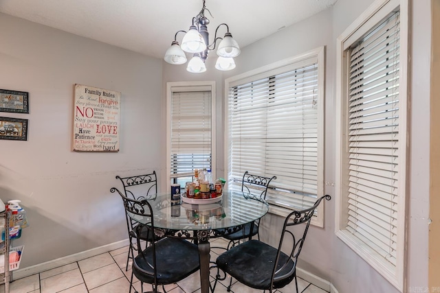 dining room featuring light tile patterned floors, baseboards, and a chandelier