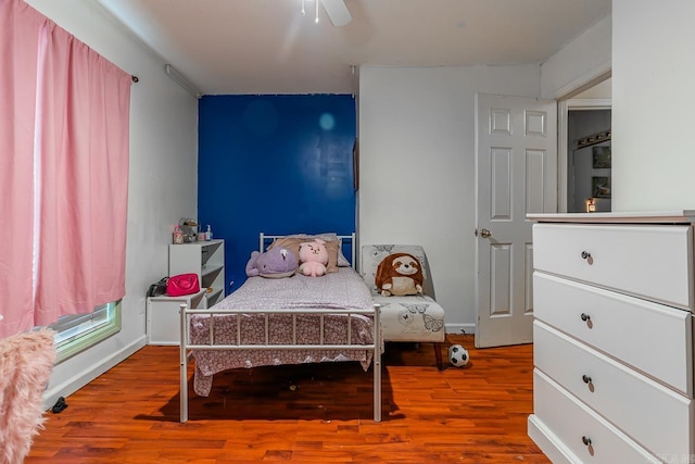 bedroom with ceiling fan, baseboards, and wood finished floors