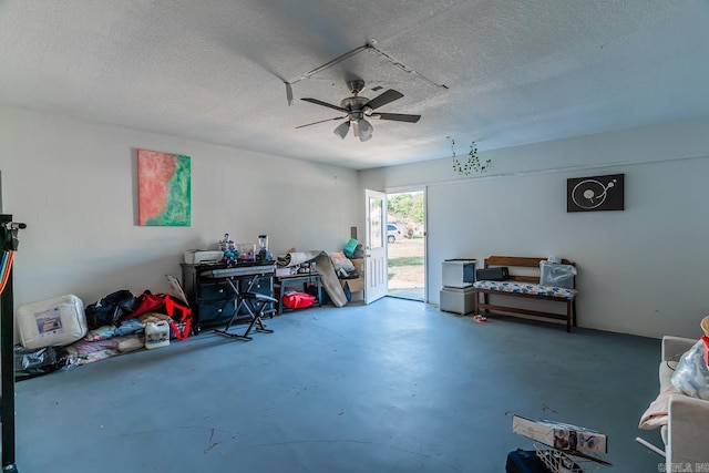 miscellaneous room featuring finished concrete floors, a textured ceiling, and a ceiling fan