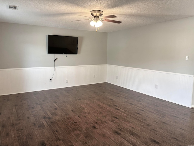 empty room with ceiling fan, dark hardwood / wood-style floors, and a textured ceiling