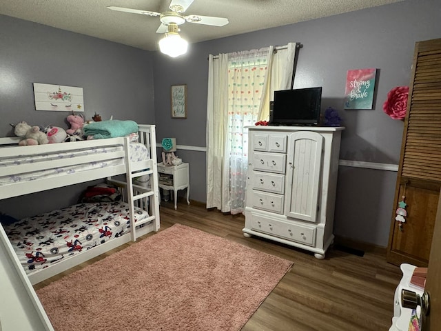 bedroom featuring ceiling fan, dark hardwood / wood-style floors, and a textured ceiling