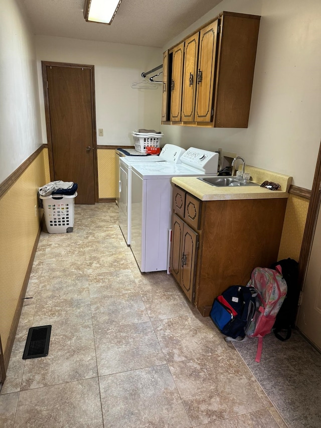 laundry room featuring cabinets, sink, light tile patterned floors, and washing machine and dryer