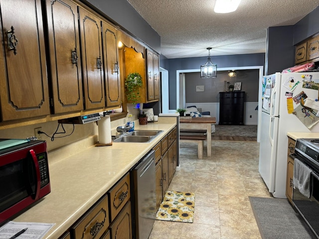 kitchen with a textured ceiling, decorative light fixtures, stainless steel dishwasher, sink, and light tile patterned flooring