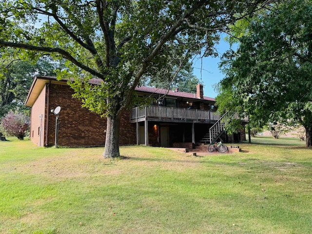 back of property with a deck and a lawn