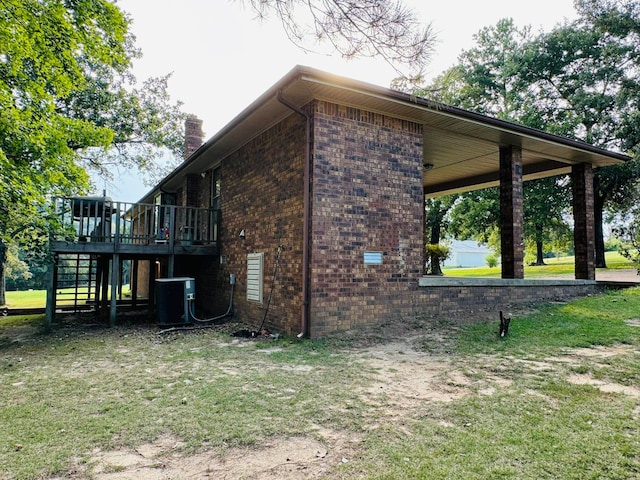 view of side of home with a yard, cooling unit, and a deck