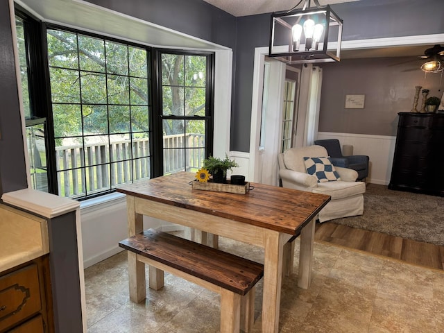 dining area with a healthy amount of sunlight, ceiling fan with notable chandelier, and light wood-type flooring