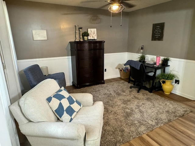 living area with ceiling fan and wood-type flooring