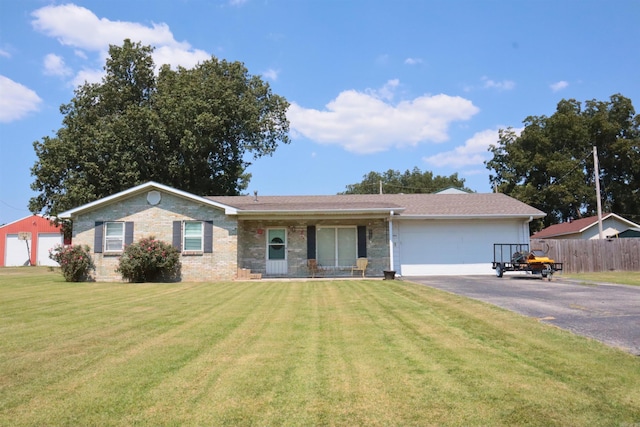 ranch-style home featuring brick siding, an attached garage, fence, driveway, and a front lawn