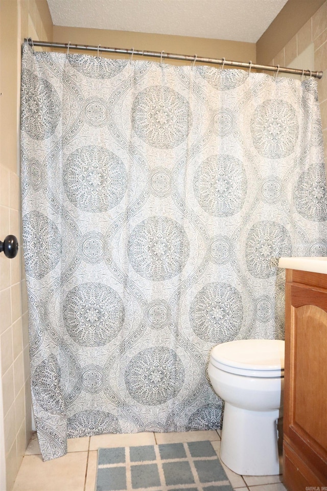 full bath with curtained shower, vanity, toilet, and tile patterned floors