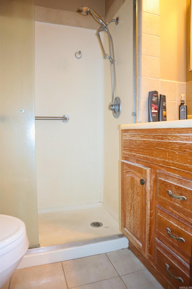 full bath featuring toilet, a shower stall, and tile patterned floors