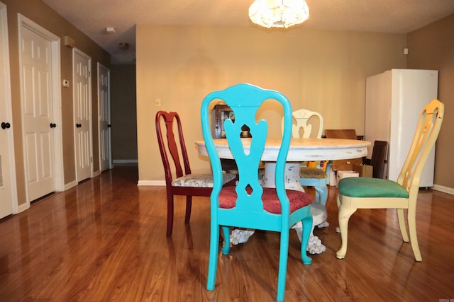 dining room with an inviting chandelier, wood finished floors, and baseboards