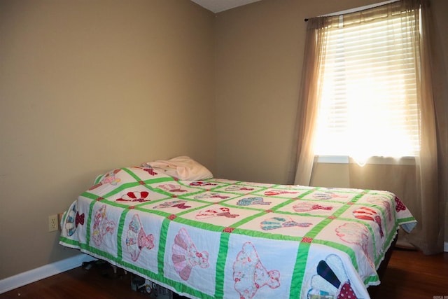 bedroom featuring baseboards and wood finished floors