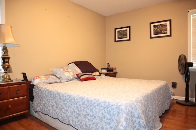 bedroom featuring baseboards and wood finished floors