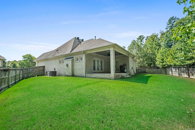 back of property featuring central AC unit, a patio area, and a lawn