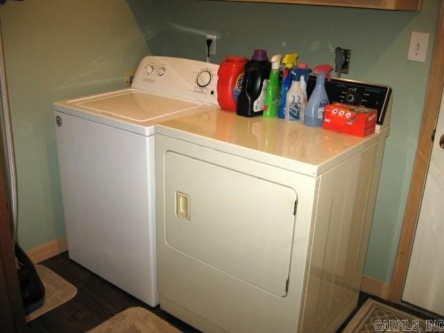 laundry room with washing machine and clothes dryer and dark hardwood / wood-style flooring