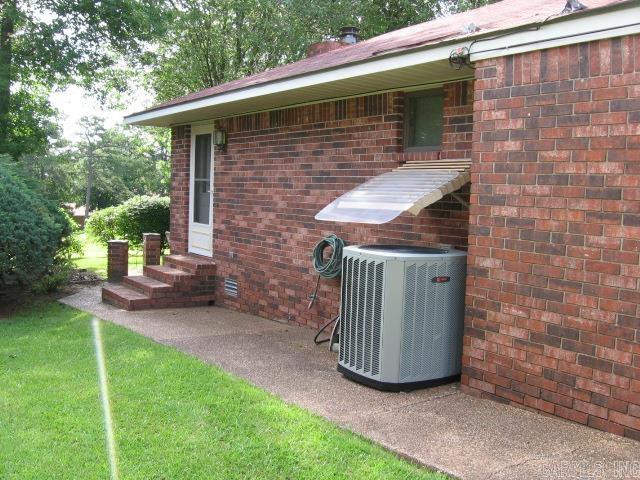 view of side of home with a lawn and central AC