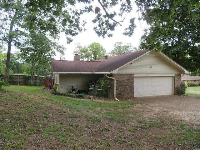 exterior space with a garage and a lawn