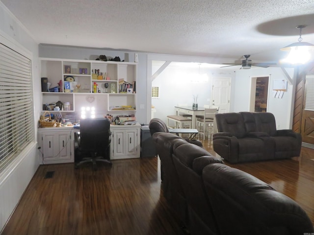 living room with a textured ceiling, ceiling fan, and dark hardwood / wood-style flooring