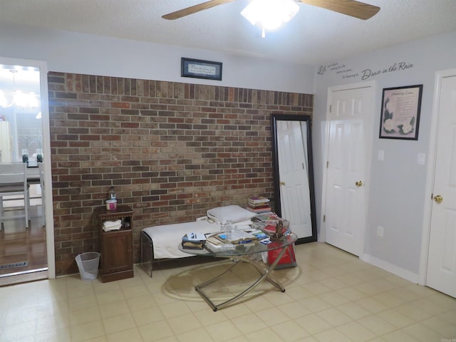 dining area with brick wall, a textured ceiling, and ceiling fan