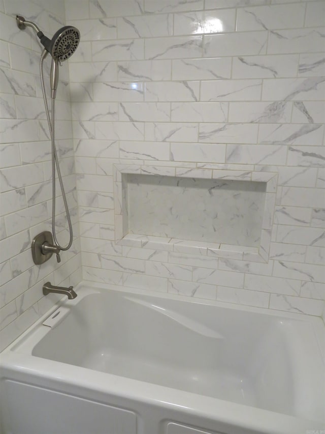 bathroom featuring tiled shower / bath