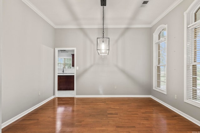 unfurnished dining area with visible vents, baseboards, wood finished floors, and ornamental molding