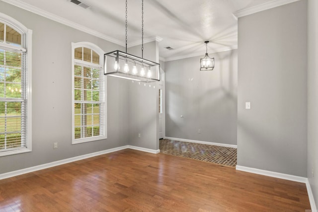 unfurnished dining area with baseboards, wood finished floors, visible vents, and crown molding