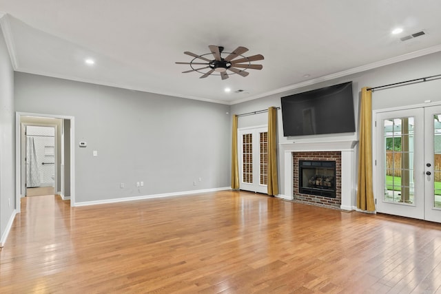 unfurnished living room with light wood-type flooring, visible vents, ornamental molding, and french doors