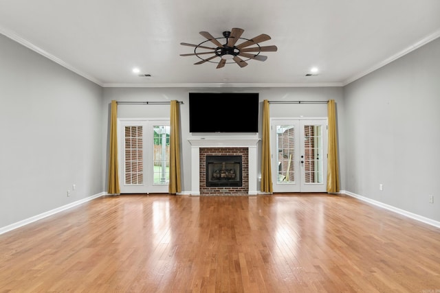 unfurnished living room featuring light wood-style floors, french doors, crown molding, and baseboards