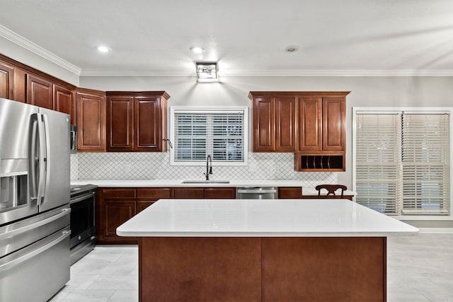 kitchen featuring light countertops, appliances with stainless steel finishes, a sink, and decorative backsplash