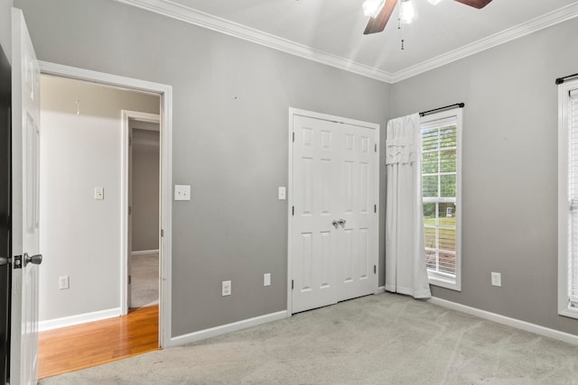 unfurnished bedroom with ornamental molding, carpet flooring, ceiling fan, and baseboards