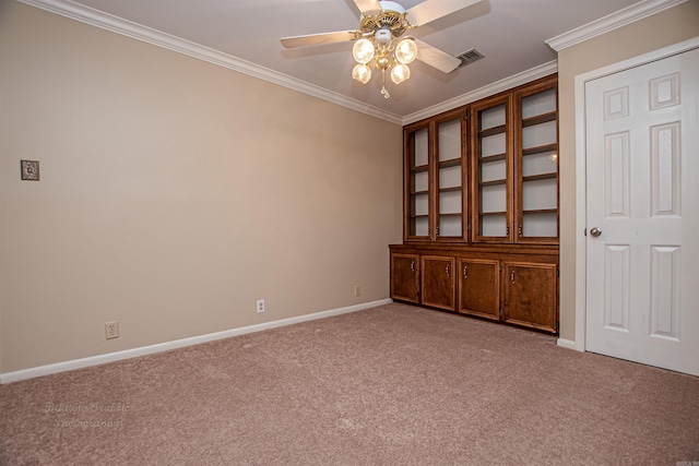 carpeted empty room featuring ceiling fan and ornamental molding