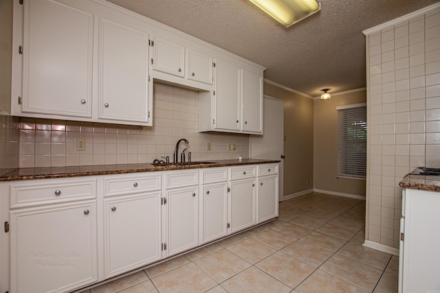 kitchen with white cabinetry, a textured ceiling, light tile patterned floors, and decorative backsplash