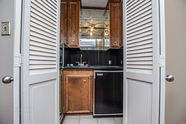 kitchen featuring light tile patterned floors, backsplash, dishwasher, and sink