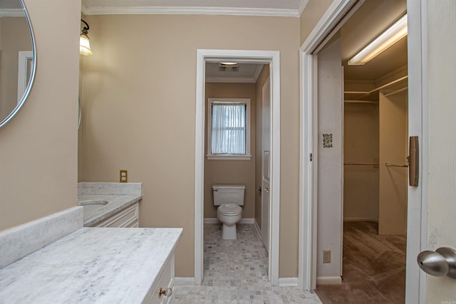 bathroom featuring toilet, ornamental molding, and vanity