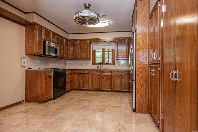 kitchen featuring appliances with stainless steel finishes, tasteful backsplash, crown molding, sink, and light tile patterned flooring