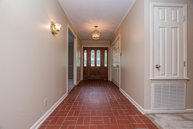 entryway with a textured ceiling and a notable chandelier