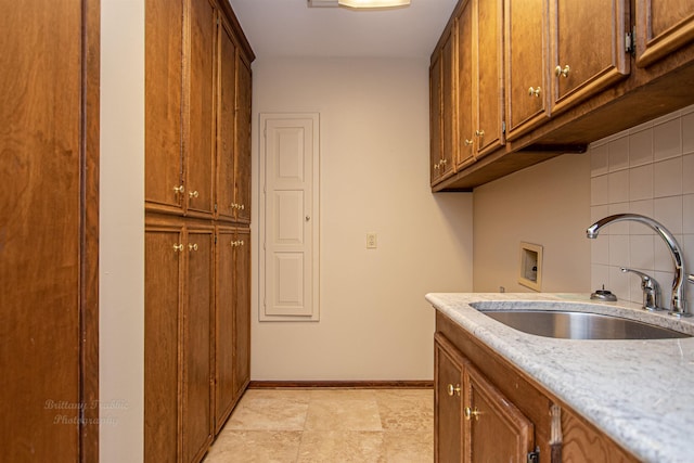 clothes washing area with cabinets, sink, light tile patterned floors, and washer hookup