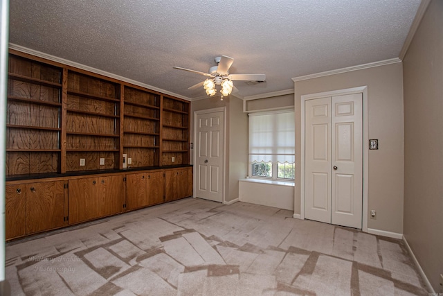 interior space with a textured ceiling, crown molding, ceiling fan, and light carpet