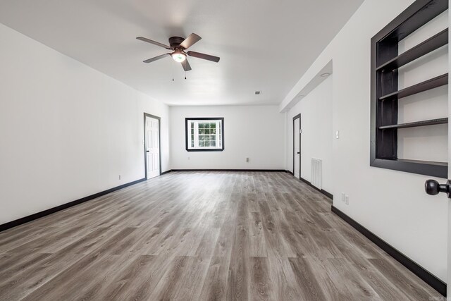 interior space featuring built in features, ceiling fan, and light hardwood / wood-style floors